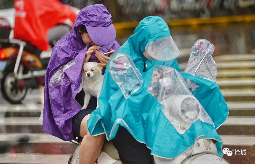 上海 - 2016年6月20日,电瓶车上穿雨衣的人.拾城 赖鑫琳