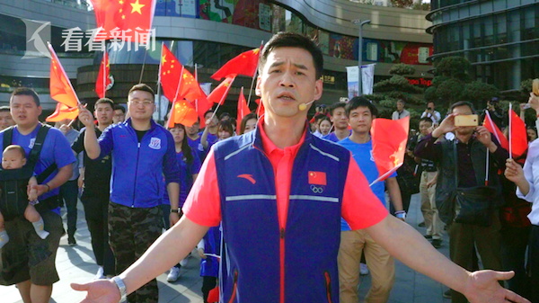 男子花剑世界冠军叶冲和高举国旗的上海绿地申花队球迷们一同加入快闪活动