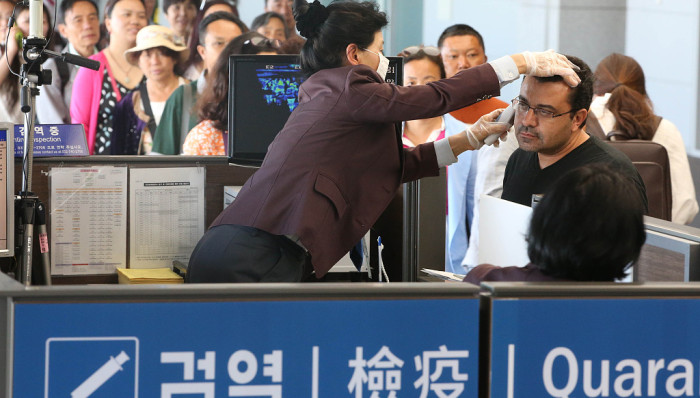 2015年6月1日，韩国仁川，机场对入镜旅客加强检测。当天，韩国中东呼吸综合征(MERS)患者新增3人，总人数增至18人。来源：视觉中国(photo:JieMian)